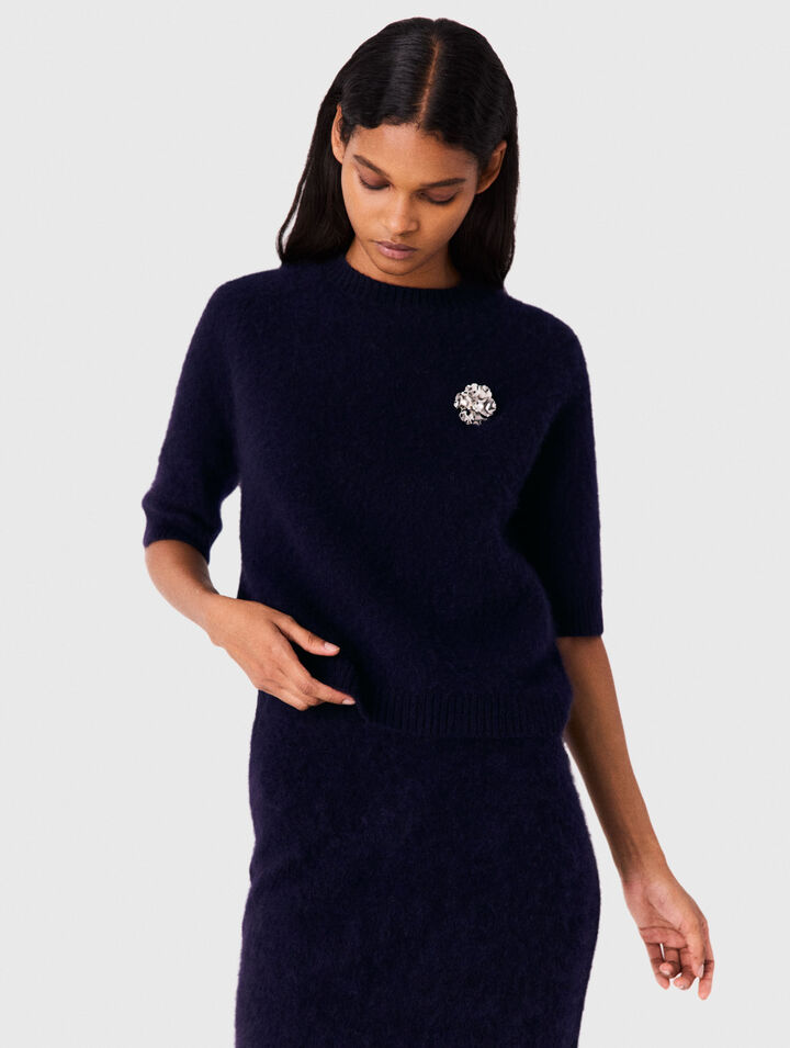Jumper with floral brooch