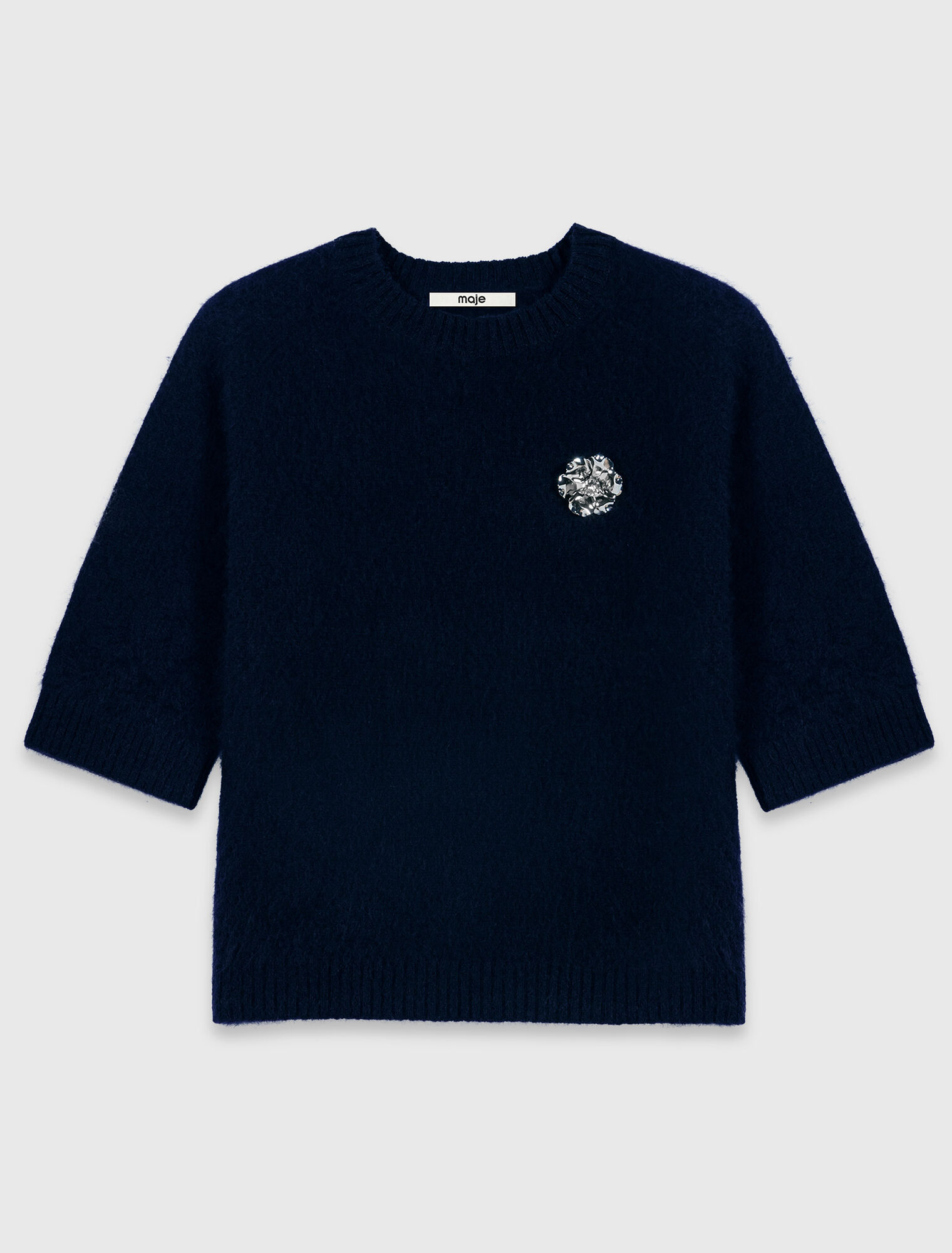 Jumper with floral brooch