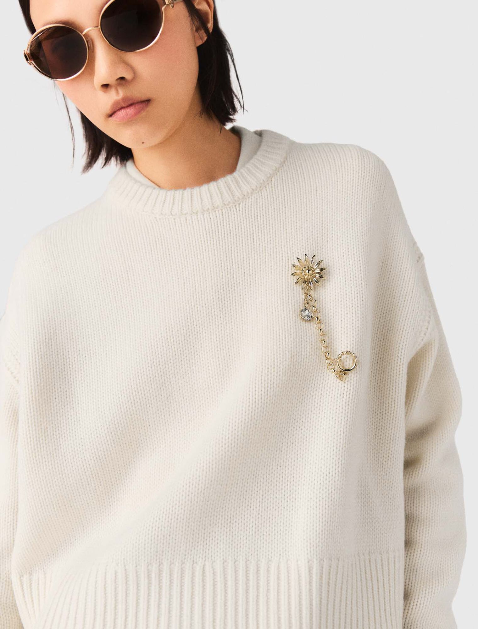 Sweater with floral brooch