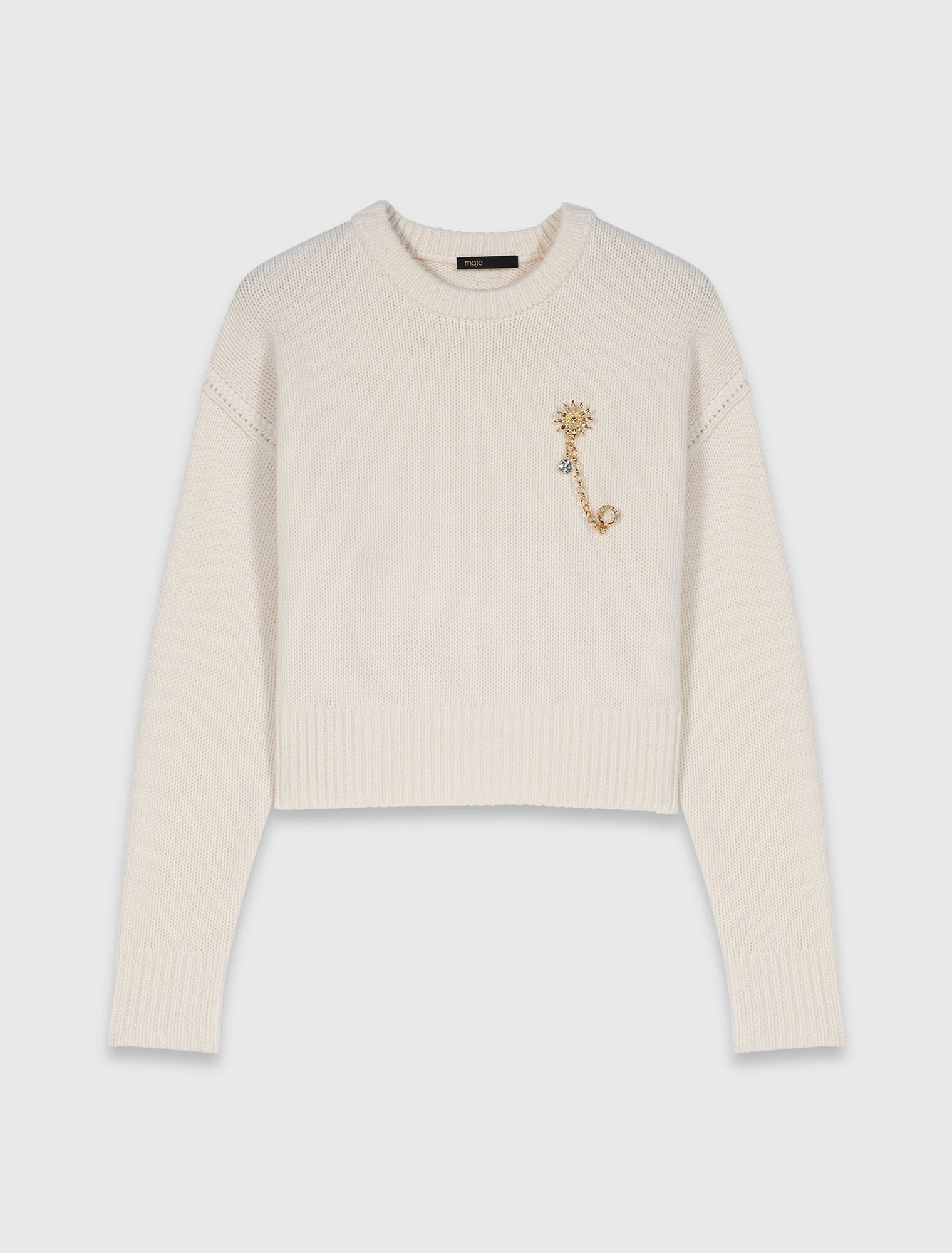 Sweater with floral brooch